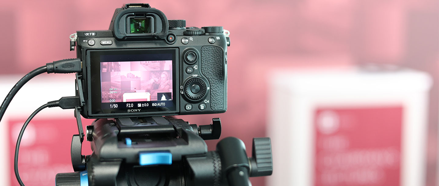 Image: close up of camera showing lectures backdrop