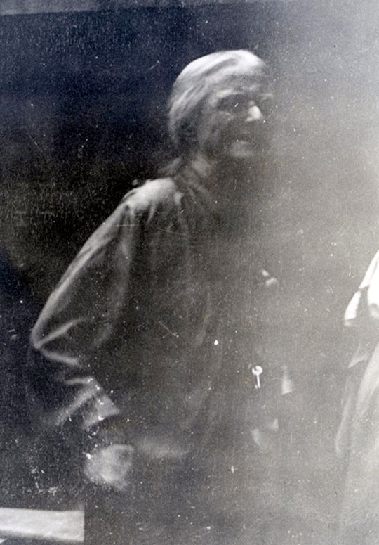 Black and white photograph of Mary Hughes,  a white woman with fair hair, glasses, and dark clothing.