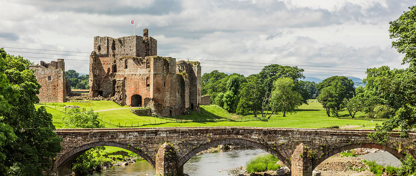 A bridge over the river with Brougham Castle in the background