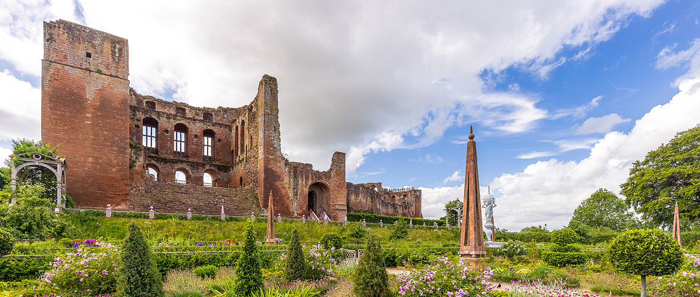 The ruins of Kenilworth Castle with the Elizabethan Garden in the foreground.