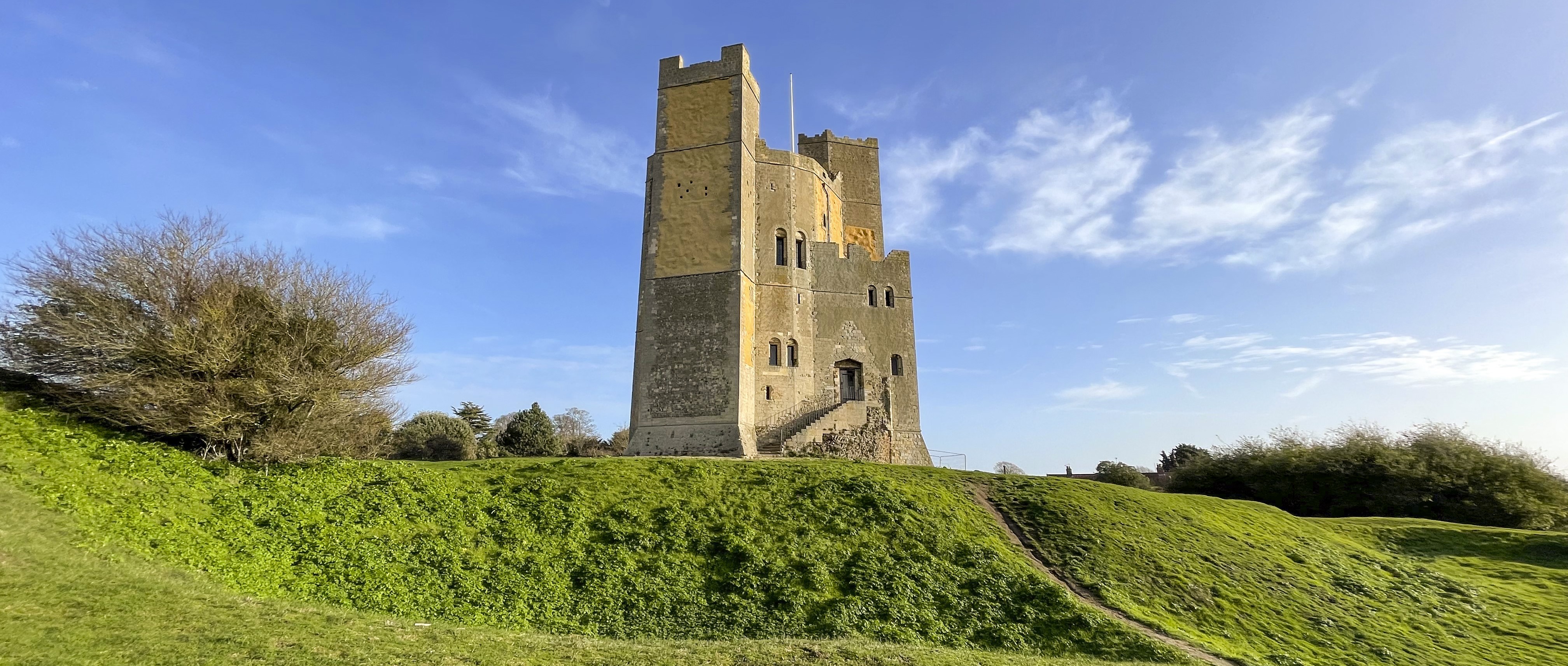 Photo of Orford Castle on a grassy hillock on a sunny day