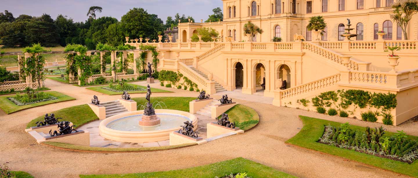 The terraces of Osborne House, peach in colour, with planted gardens and a fountain
